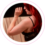 Une femme rousse posant dans un boudoir