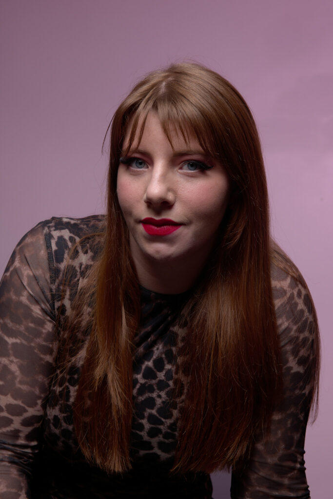 Femme souriante, éclairage de studio créant une ambiance professionnelle et stylée.